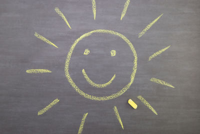 Directly above shot of sun drawn on blackboard