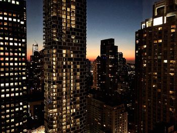 Illuminated buildings in city against sky at night