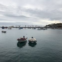 Fishing boats in sea against sky