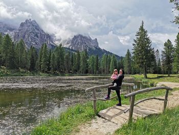 Portrait of mother carrying daughter while standing by lake