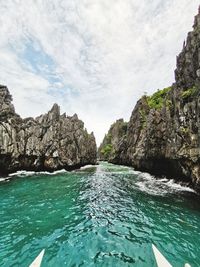 Rock formations by sea against sky