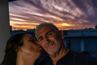 Side view of man looking away against sky during sunset