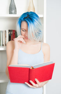 Woman with blue hair reading book