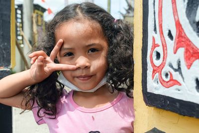 Little girl showing ring and index finger as a word of peace