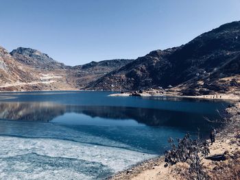 Scenic view of lake and mountains against clear sky