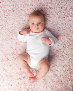 High angle portrait of cute baby lying on bed