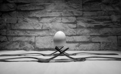 Close-up of egg on forks against stone wall