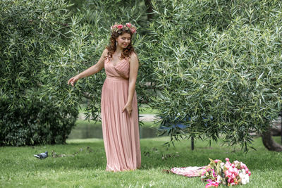 Portrait of young woman standing on grassy field