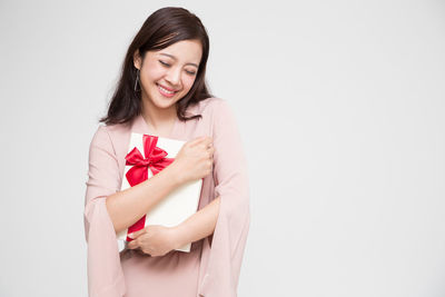 Beautiful young woman smiling against white background