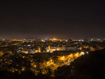 High angle view of illuminated buildings against sky at night