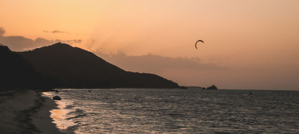 Scenic view of sea against sky during sunset and some kite surfing 