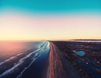 Road amidst landscape against clear sky during sunset