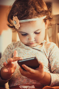 Close-up of cute girl using mobile phone