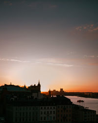 Silhouette buildings against sky during sunset