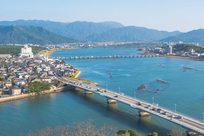 High angle view of sea and cityscape against sky
