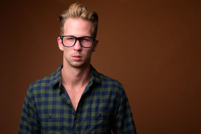 Portrait of young man against black background