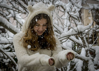 Smiling girl standing during snowfall