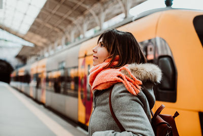 Woman looking at train in city during winter