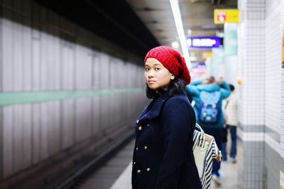 Portrait of woman standing at railroad station platform