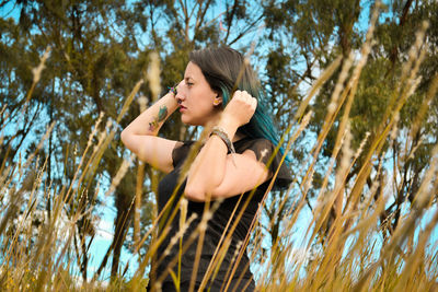 Low angle view of woman standing against trees