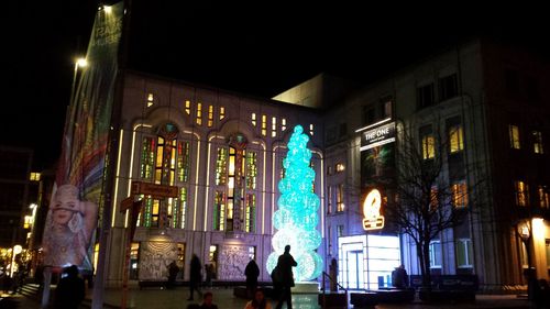 People in illuminated city at night