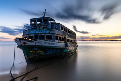 Boat moored in sea against sky