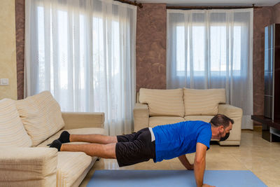 Man wearing flu mask exercising at home