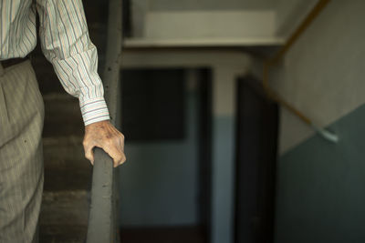 Midsection of man standing by wall