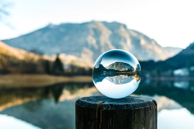 Close-up of crystal ball against calm lake