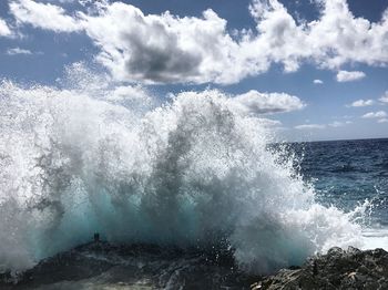 Water splashing in sea against sky