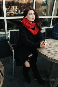 Portrait of a young woman sitting on ground