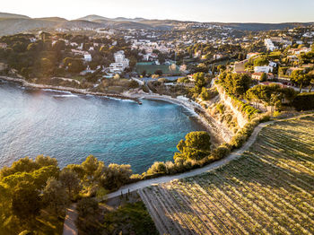 Aerial view of cityscape by sea during sunset