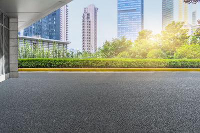 Road by buildings in city against sky