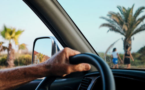 Midsection of man seen through car windshield