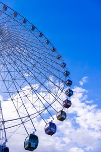 Low angle view of ferris wheel against blue sky