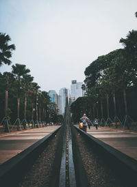 Railroad tracks in city against clear sky