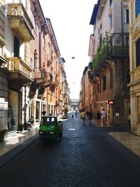 Cars on street in city against clear sky