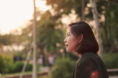 Portrait of young woman looking away outdoors