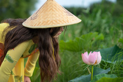 Close-up of girl with pink flowering lotus plants 