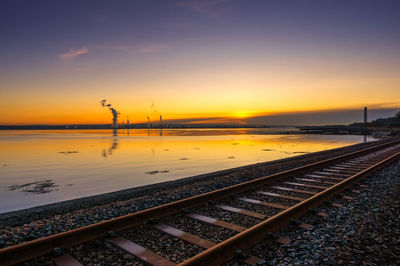 Railroad tracks against sky during sunset