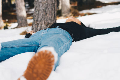 Teenage girl lying on snow during winter