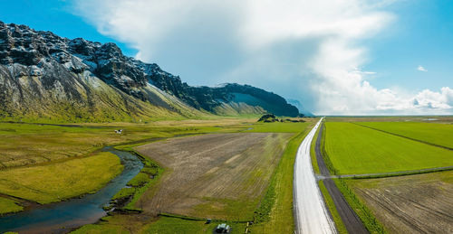 Endless road into the cloudy mountains and hills of iceland during sunny cloudy weather.