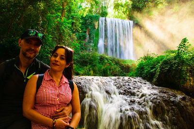 Portrait of young couple against waterfall