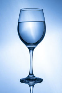 Close-up of wineglass against blue background