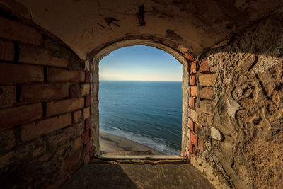 Scenic view of sea against sky seen through window during sunset