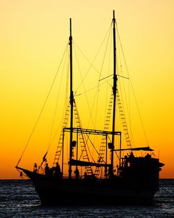 Silhouette sailboat sailing on sea against romantic sky