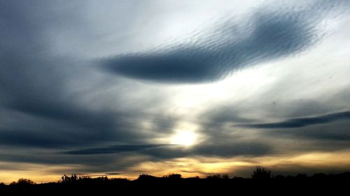 Silhouette of landscape against cloudy sky