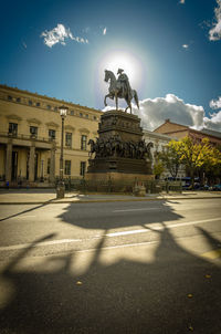 Statue in city against sky