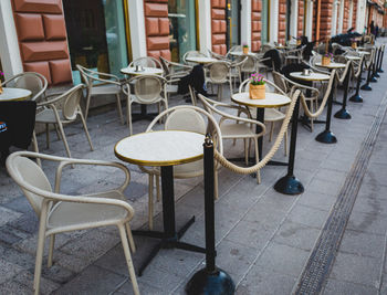 Empty  restaurant chairs and tables  on street 