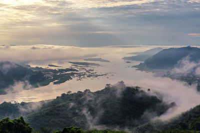 High angle view of sea by mountains during sunset